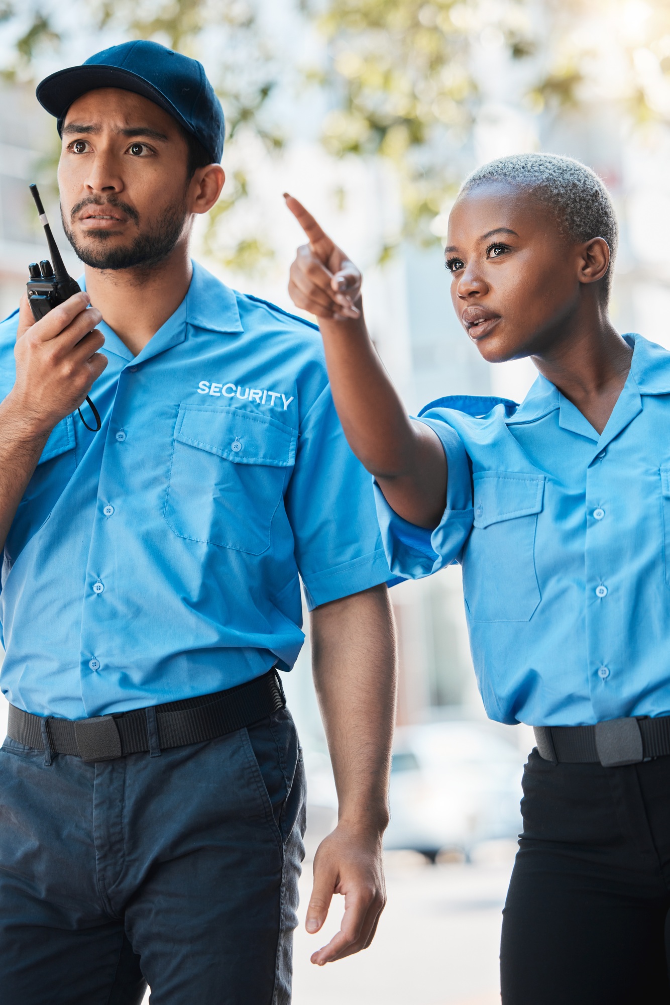 Security guard, safety officer and pointing on street for protection, patrol or watch for danger. L